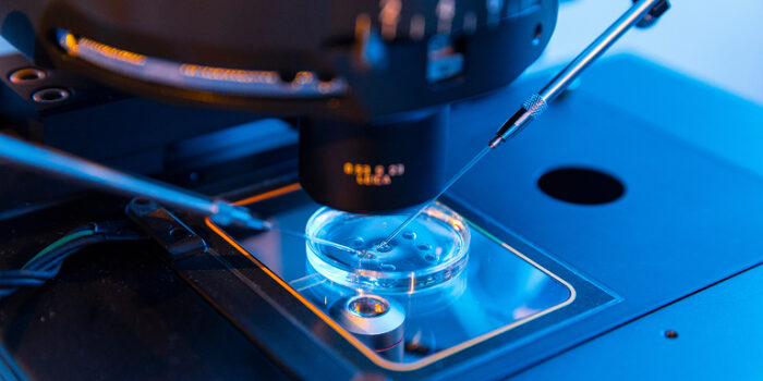 Advanced in vitro diagnostics laboratory with microscope and precision pipetting during medical device research and testing